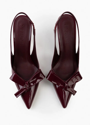 Bordo LUCINDA Slingback-Pumps aus glänzendem Lackleder mit spitzer Vorderkappe, mittelhohem schmalen Absatz und verstellbarem Slingback-Riemen. Dekorative Schleife auf der Vorderseite.