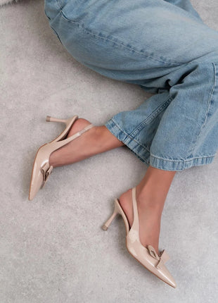 Beige LUCINDA Slingback-Pumps aus glänzendem Lackleder mit spitzer Vorderkappe, mittelhohem schmalen Absatz und verstellbarem Slingback-Riemen. Dekorative Schleife auf der Vorderseite.