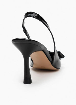 Schwarze LUCINDA Slingback-Pumps aus glänzendem Lackleder mit spitzer Vorderkappe, mittelhohem schmalen Absatz und verstellbarem Slingback-Riemen. Dekorative Schleife auf der Vorderseite.