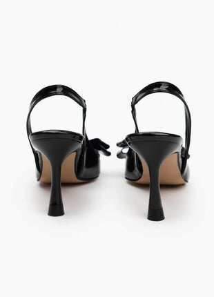 Schwarze LUCINDA Slingback-Pumps aus glänzendem Lackleder mit spitzer Vorderkappe, mittelhohem schmalen Absatz und verstellbarem Slingback-Riemen. Dekorative Schleife auf der Vorderseite.